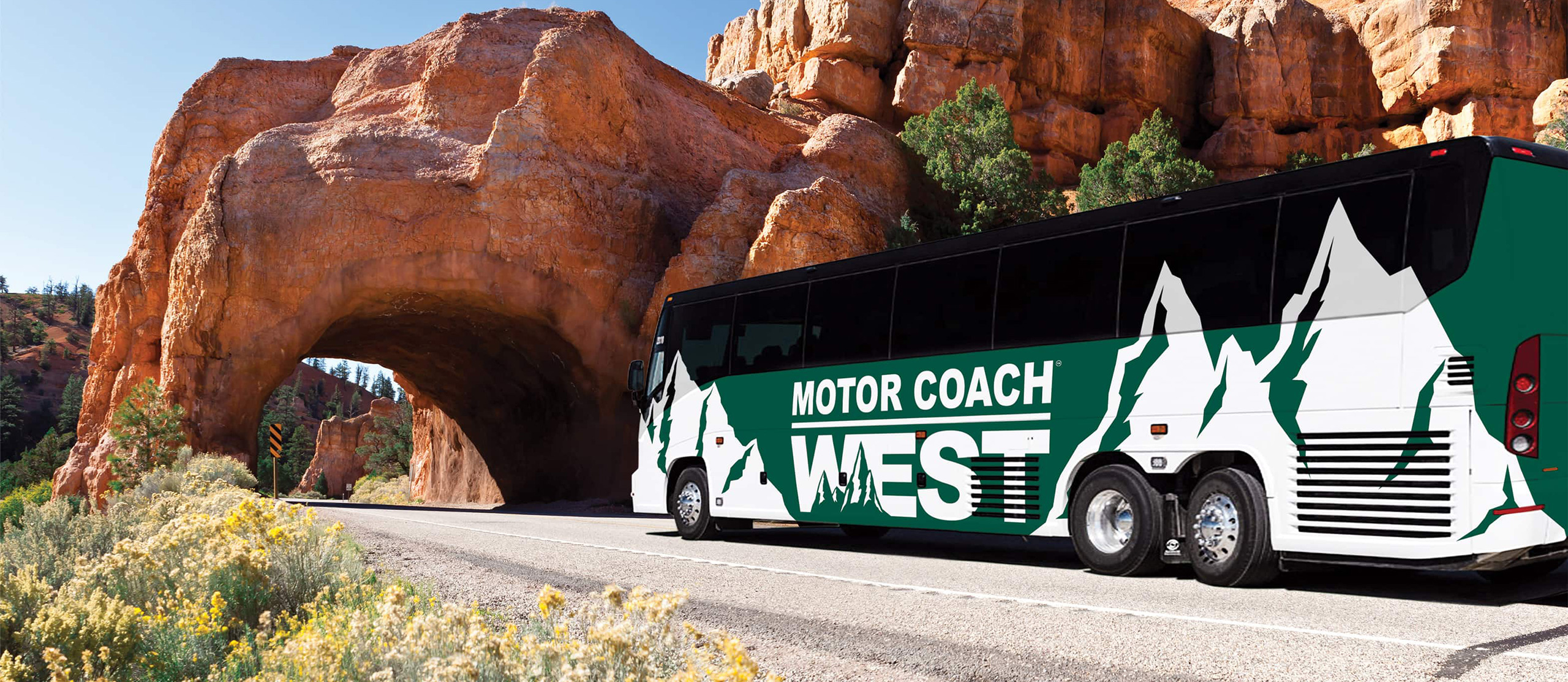 Green Motor Coach West bus entering a rock tunnel.