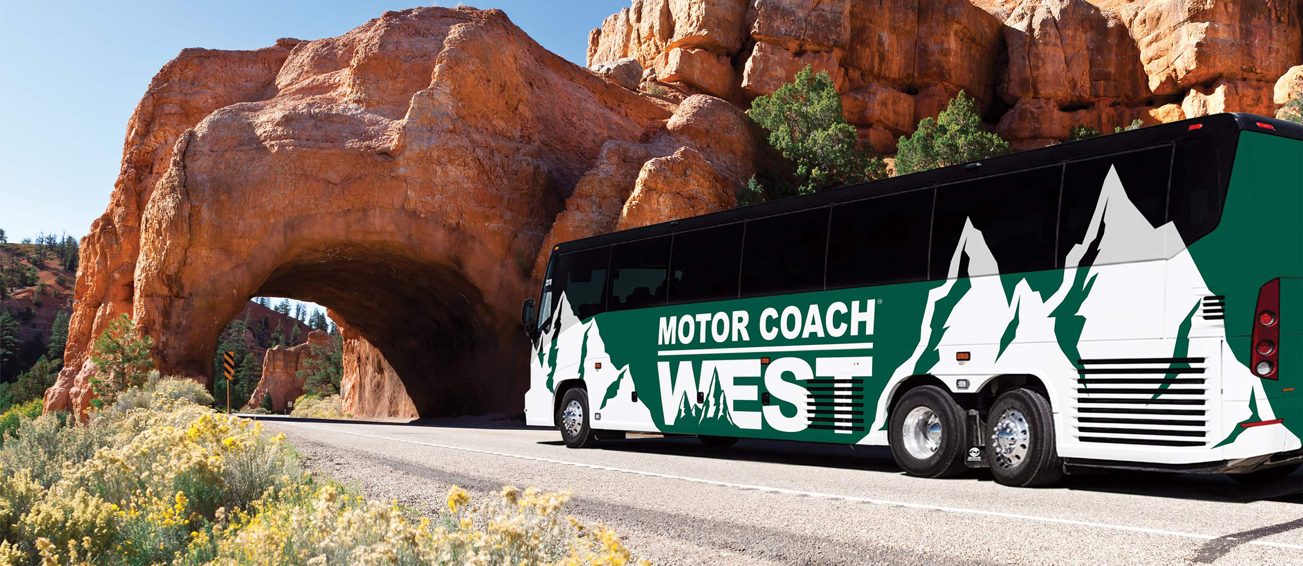Green Motor Coach West bus entering a rock tunnel.