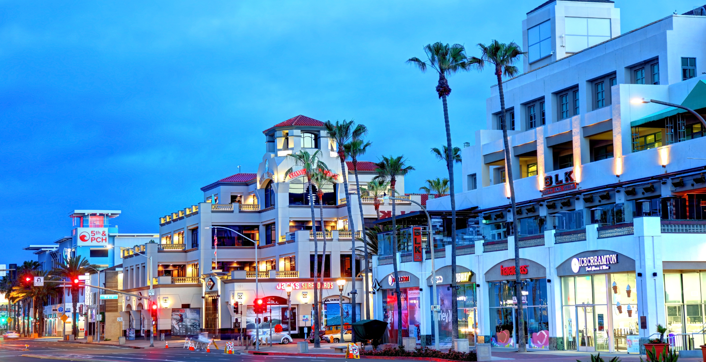 A view of a city street with lights and palm trees in California.