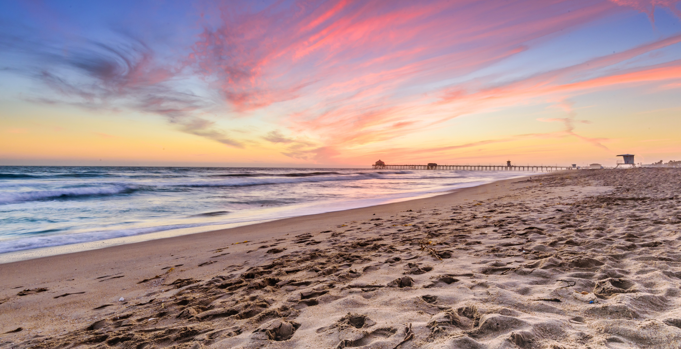 A view of sunset from the sandy shore on a beach in California