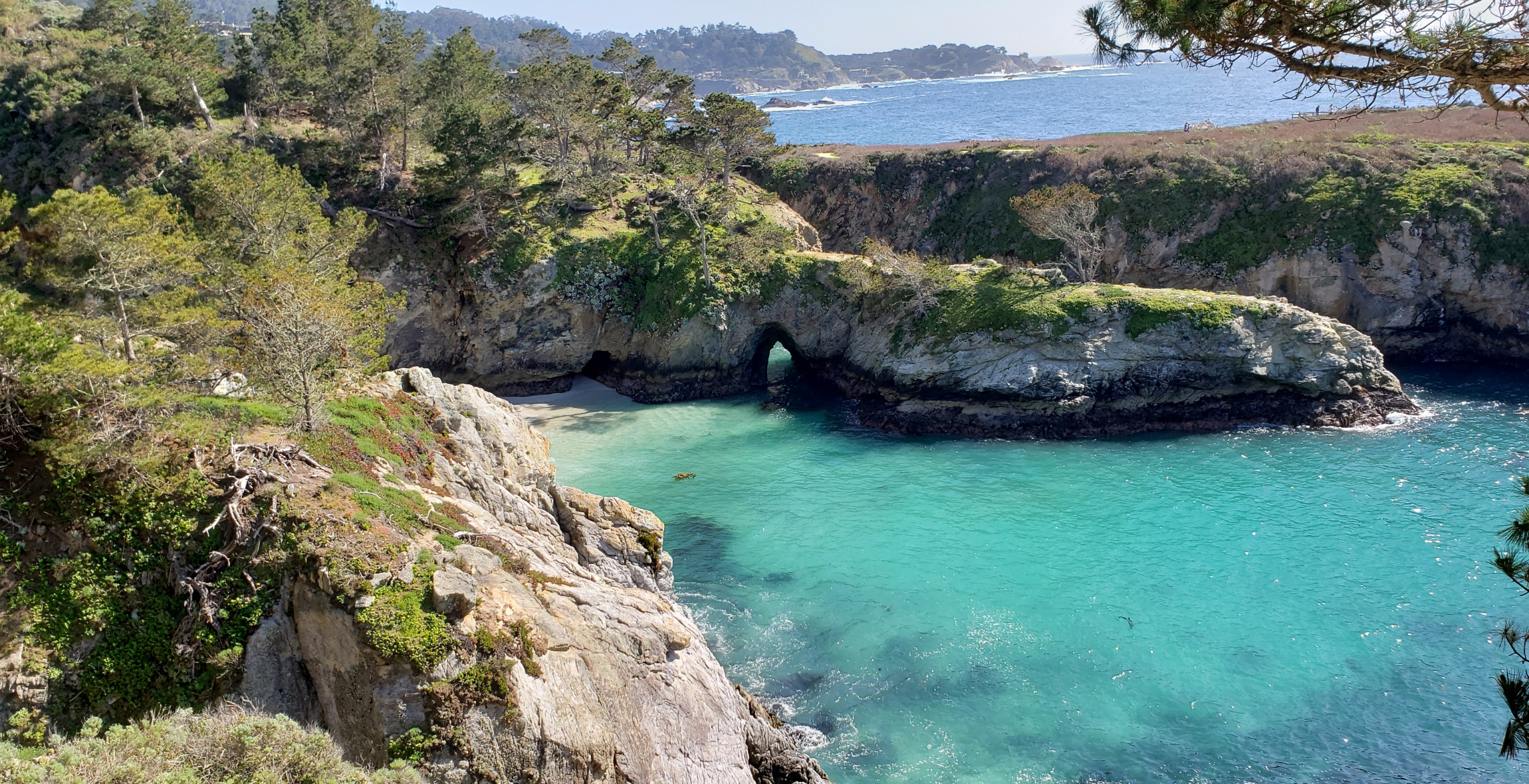 Bright blue water in the ocean surrounded by cliffs and rocks