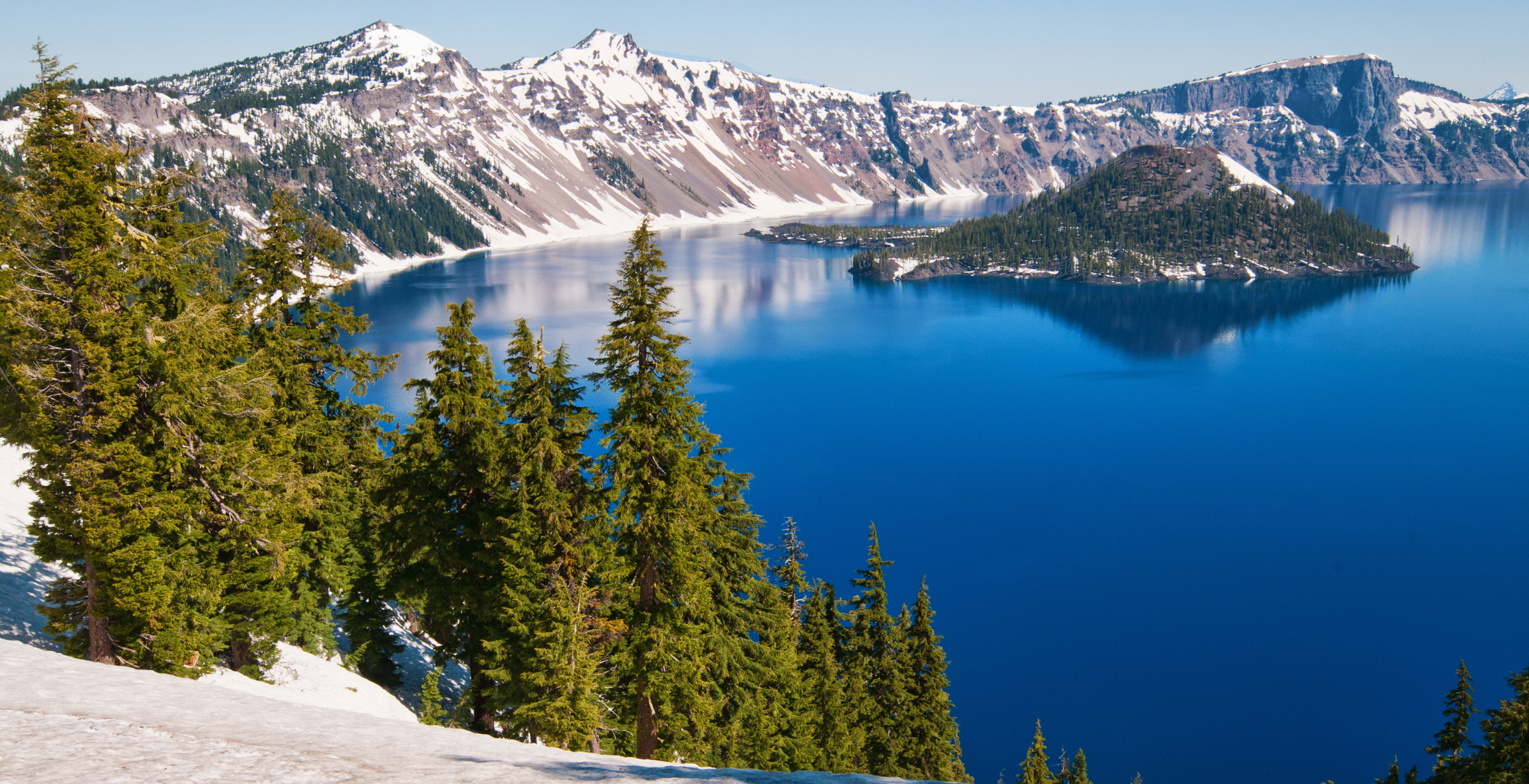 Mountains, trees and a blue lake at Crater National Park in Oregon USA