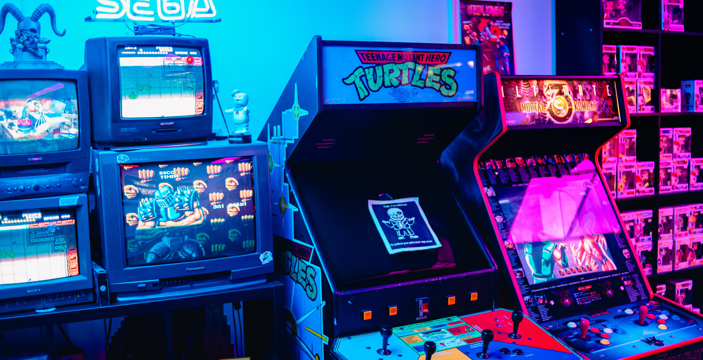 Video and Arcade games lined up in a neon lighted room