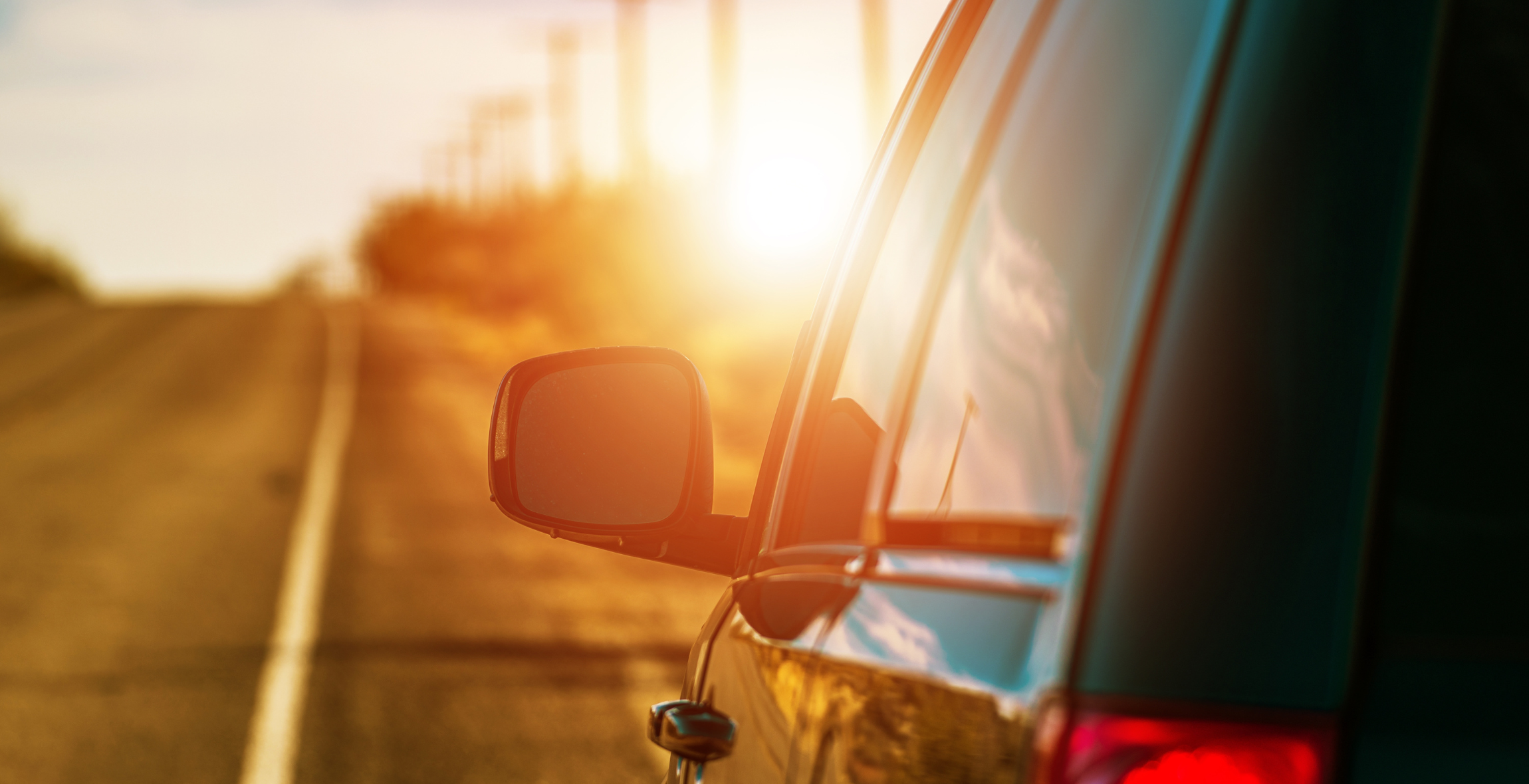 view of rear view mirror of a car driving down the road