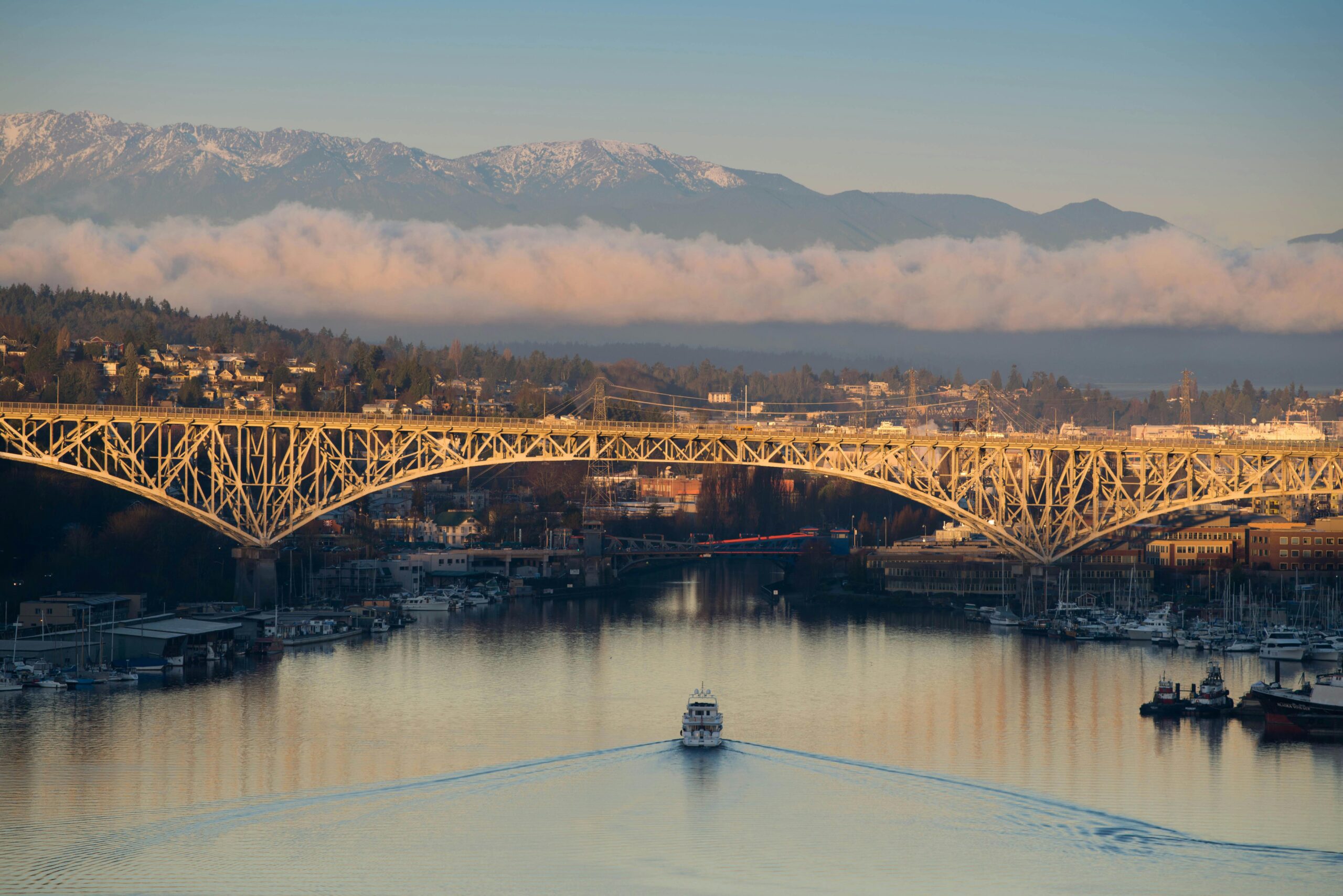 boat under bridge with a view of the mountains